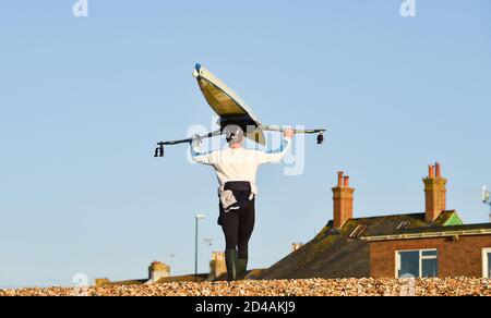 Brighton Royaume-Uni 9 octobre 2020 - les amateurs de Shoreham Rowing Club emballez leurs bateaux après avoir profité d'une belle matinée calme et ensoleillée au port de Shoreham près de Brighton . : crédit Simon Dack / Alamy Live News Banque D'Images