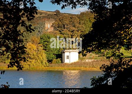 Édimbourg, Écosse, Royaume-Uni. 9 octobre 2020. Température fraîche de sept degrés avec une brise, photo: Le Loch Duddingston avec le soleil du matin brillant sur la Tour de Thomson au milieu du sol et Duddingston Kirk niché avec les arbres dans le jardin du Dr Neil encadré par la silhouette des branches d'arbres au premier plan. Tour conçue par William Henry Playfair construite en 1825 pour que la Duddingston Curling Society stocke ses pierres. Un lieu de rencontre pour les conservateurs et un studio pour l'artiste respecté le Rév. John Thomson, ministre de Duddingston de 1805 à 1840. Crédit : Arch White/Alamy Live News. Banque D'Images