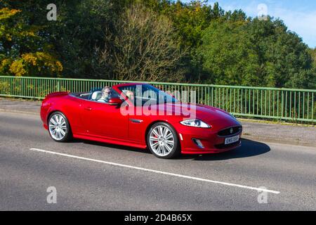 2013 Red British Jaguar XK R auto cabriolet ; circulation automobile, véhicules en mouvement, voitures, conduite de véhicules sur les routes britanniques, moteurs, automobile sur l'autoroute M6 réseau routier britannique. Banque D'Images