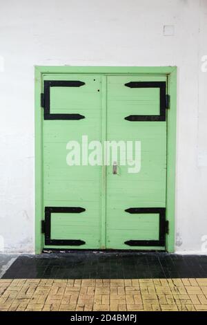 Ancienne porte en bois vert dans un mur blanc, texture photo d'arrière-plan Banque D'Images