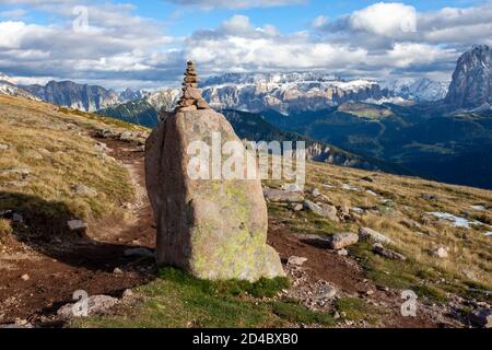 Un tas de roches empilées marque un chemin le long d'une colline en pente près du groupe de pics de Langkofel dans la région des Dolomites du Tyrol du Sud, en Italie Banque D'Images