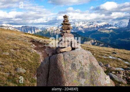 Un tas de roches empilées marque un chemin le long d'une colline en pente près du groupe de pics de Langkofel dans la région des Dolomites du Tyrol du Sud, en Italie Banque D'Images