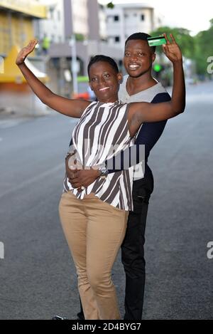 jeune couple debout dans la rue regardant la caméra sourire. Banque D'Images