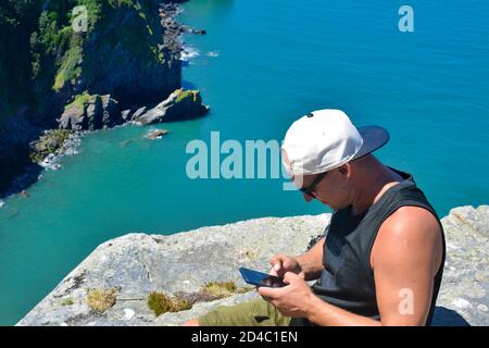 Homme utilisant son smartphone dans un endroit magnifique. Banque D'Images