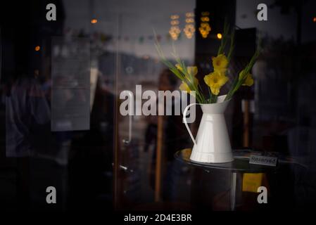 pichet de jonquilles et panneau réservé sur une table de café Banque D'Images