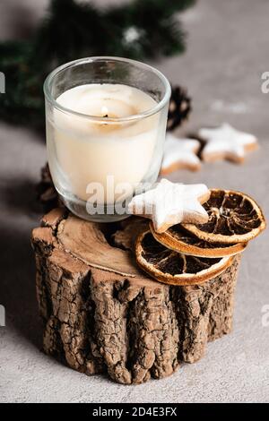 Foyer sélectif de bougie avec des tranches d'orange séchées et des biscuits sur support en bois Banque D'Images