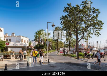 Touristes dans la rue Bodrum avec des hôtels, des restaurants, des boutiques et de hauts palmiers Banque D'Images