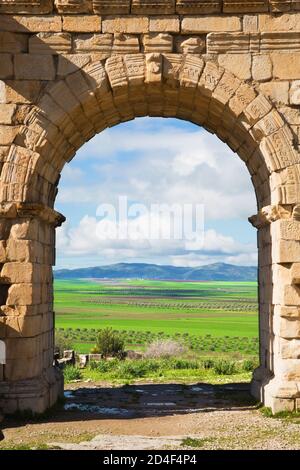 Arc à Volubilis, ancienne ville romaine au Maroc. Par elle est visible le pays fertile et vert marocain. Banque D'Images