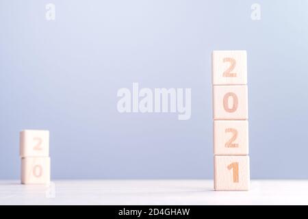 2021 Nouveau concept de conception abstrait de l'année - nombre cubes de bois de bloc isolés sur table en bois et fond bleu clair de brume. Banque D'Images