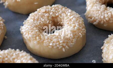 Gros plan de graines de sésame collées à la pâte, petits bagels aux graines de sésame, Banque D'Images