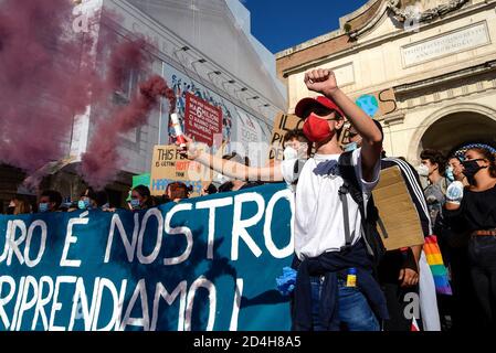 Rome, Italie. 09e octobre 2020. Un manifestant fait un geste tout en tenant un halo de fumée à la Piazza del Popolo pendant la démonstration. Des étudiants, des citoyens et des activistes du "vendredi de l'avenir" ont participé à la grève nationale du climat à Rome, pour appeler la classe politique à prendre des mesures contre la dégradation du climat et la pollution de l'environnement. Crédit : SOPA Images Limited/Alamy Live News Banque D'Images