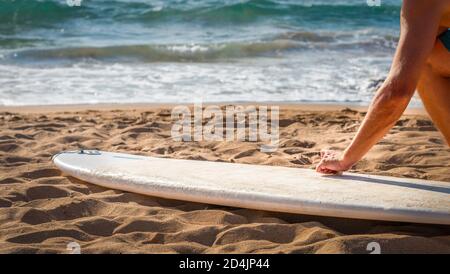 Homme à la cire une planche de surf sur la plage avant le surf session Banque D'Images