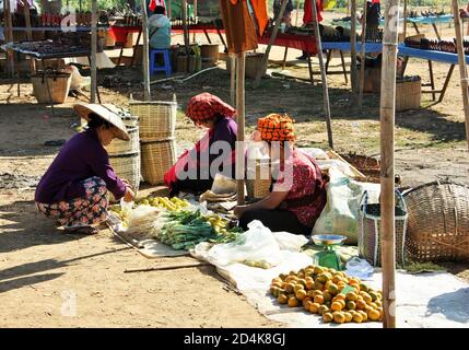 Lac Inle, État de Shan / Myanmar - 18 décembre 2019: Les gens de l'ethnie Pa'O locale portant des vêtements traditionnels dans une cabine de légumes au marché de Phaung Daw Oo Banque D'Images