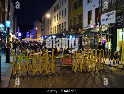 Covid-19 panneau de restrictions temporaires et barrière de circulation sur Old Compton Street, Soho la nuit. De nombreuses rues du centre de Londres ont été bloquées pour la circulation afin de permettre aux bars et restaurants de s'asseoir en plein air pendant la pandémie. Banque D'Images