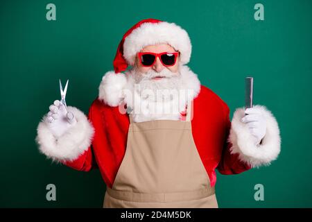 Gros plan portrait de son beau beau barbu graisse en surpoids Santa grand-père styliste ouvrier portant un tablier tenant dans les mains coupe de cheveux outils Banque D'Images