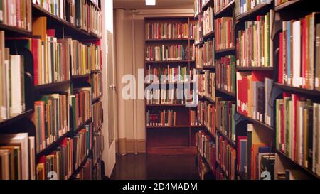 Livres sur les étagères de la bibliothèque publique, arrière-plan flou. Livre d'école dans la bibliothèque beau concept. Banque D'Images