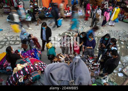 Les vendeurs de rue portant des masques de visage ont vu vendre des vêtements sur le marché dans le contexte de la propagation de la maladie de coronavirus.comme la saison du festival de Dashain est juste au coin de la rue, les marchés de la capitale sont de plus en plus occupés et bondés. Banque D'Images