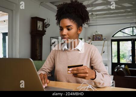 Femme effectuant le paiement par carte de crédit à la maison tout en faisant des achats en ligne pendant le verrouillage Banque D'Images