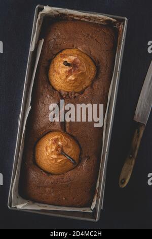 Gâteau au chocolat vegan maison avec poires pochées. Vue de dessus, plan d'appartement. Banque D'Images