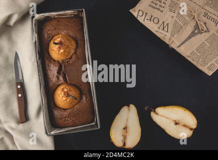 Gâteau au chocolat vegan maison avec poires pochées. Vue de dessus, plan d'appartement. Banque D'Images