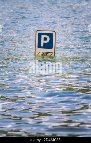 Panneau de route de stationnement partiellement submergé par une inondation. La lettre P indique le stationnement pour les voitures. Inondations dues à de très fortes perturbations climatiques. Emplacement : Banque D'Images