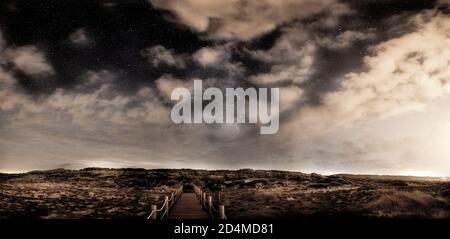 Photo spectaculaire prise sur la plage préservée de son Serra de Marina, Majorque, avec la voie laiteuse qui menace à travers les nuages et un chemin en bois sur le bea Banque D'Images
