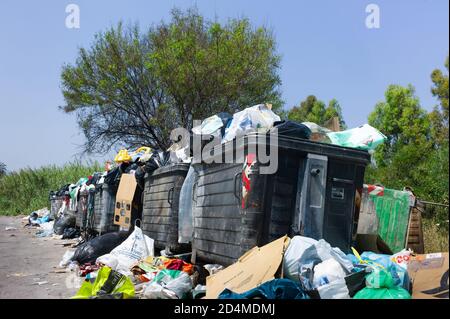 Conteneurs à ordures débordant et sacs à ordures ouverts déchirés sur le bord d'une rue en raison d'une grève de la municipalité de Sicile, Italie Banque D'Images