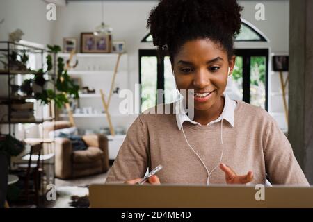 femme de race mixte en conférence téléphonique à la maison. Banque D'Images