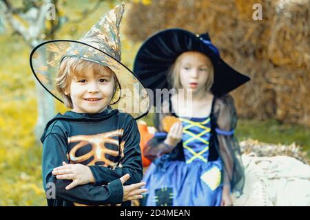 Deux enfants comme squelette ou sorcière prêt pour le truc ou le plaisir. Groupe surprise petit zombie dans Halloween déguisements manger traite, calaverita sucreries bougies. Banque D'Images