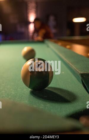 sur une table de billard se trouve une boule de billard devant d'un trou Banque D'Images