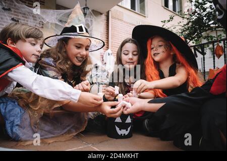 Enfants partageant et comparant leurs bonbons à halloween Banque D'Images