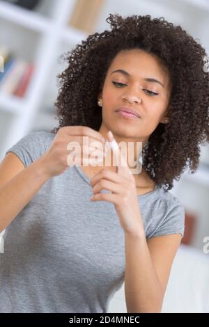 une femme colle un doigt coupé à l'aide d'un bracelet Banque D'Images