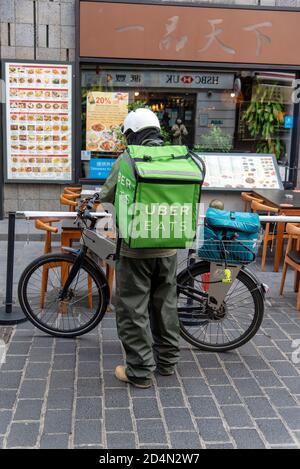 Londres, Royaume-Uni. 09e octobre 2020. Un passager Uber Eats attend devant un restaurant de Chinatown, Londres pour récupérer un ordre de livraison. Crédit : SOPA Images Limited/Alamy Live News Banque D'Images