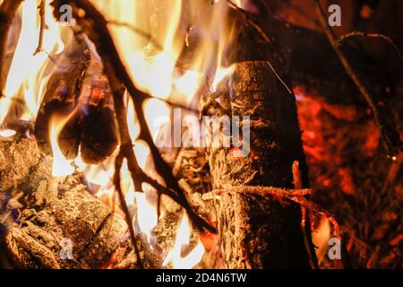 Détails d'un feu de bois dans une cheminée en brique rouge creusé dans le sol Banque D'Images