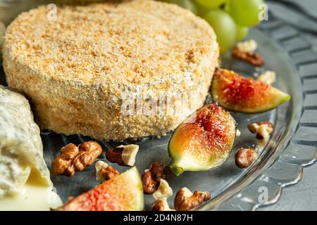 Camembert aux raisins, noix et figues gros plan sur fond gris Banque D'Images