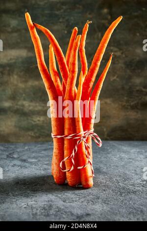 La nourriture est horrible. Carottes organiques déformées sur fond bleu. Produits déformés, problème de déchets alimentaires concept. Banque D'Images