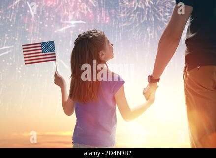 Vacances patriotiques. Enfant assis sur les épaules de son père et tenant le drapeau des États-Unis. L'Amérique fête le 4 juillet. Banque D'Images