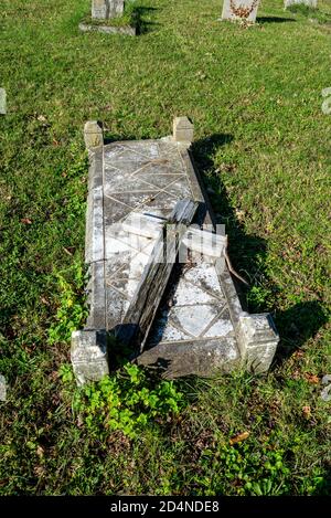 Croix de bois pourri sur la tombe à St Mary le cimetière de l'église de la Vierge à Hawkwell, Rochford, près de Southend, Essex, Royaume-Uni. Décroissance, rupture de la croix Banque D'Images