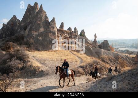 Cappadoce, Turquie. 8 novembre 2017 Canan dirige un groupe de trekking à cheval de touristes à travers le paysage volcanique de la Cappadoce dans le centre d'Anatoli Banque D'Images