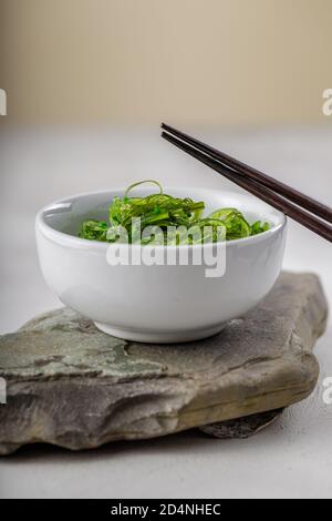 Photo croppée de salade d'algues wakame vertes avec baguette au le restaurant Banque D'Images