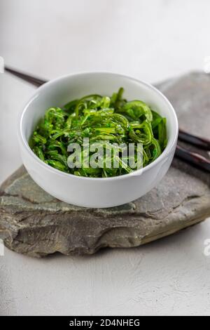 Photo croppée de salade d'algues wakame vertes avec baguette au le restaurant Banque D'Images