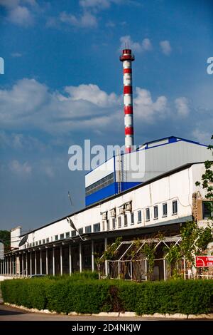 Usine de verre Darkhan. Centrale à gaz à rayures rouges et blanches, cheminée et bâtiment industriel. Ciel bleu, nuages. Ville de Shymkent, Kazakhstan Banque D'Images