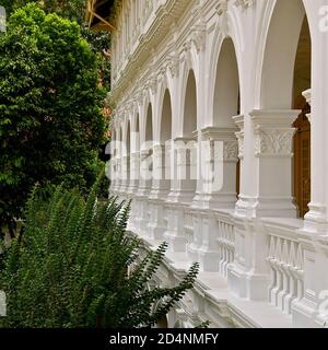 Vue en perspective d'une rangée d'arches dans un bâtiment colonial blanc. Banque D'Images