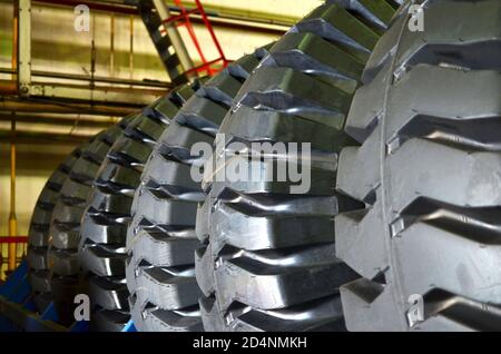 Entrepôt avec pneus pour camions à une installation industrielle pour la production de voitures. Le protecteur d'une grande roue en caoutchouc. Rouleau en caoutchouc de la benne. Banque D'Images