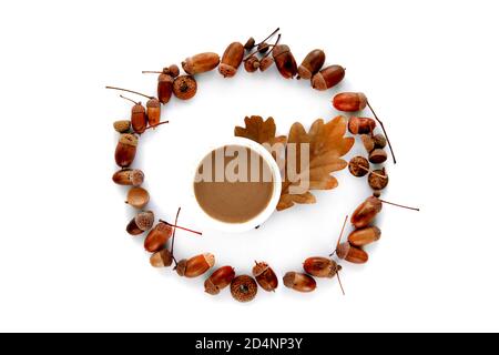 Composition d'automne. Cadre fait de feuilles séchées brunes, d'acornes et d'une tasse de café isolée sur fond blanc. Maquette automne, halloween Banque D'Images