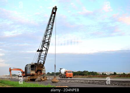De grandes grues sur chenilles pelle à benne traînante ou avec un métal lourd boulet sur un câble en acier. Wrecking balles sur les chantiers de construction. Démontage et dem Banque D'Images