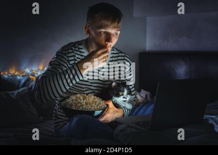 Jeune Homme Avec Chat Noir Regardant Un Film En Train De Manger Du Pop Corn A La Television A La Maison Soiree Cinema Detendez Vous Et Regardez Un Film D Horreur Ou Une Video A