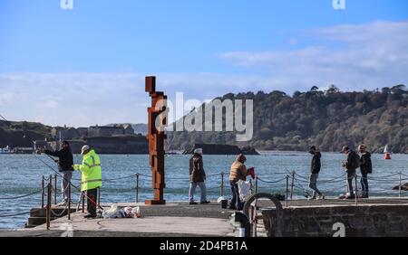 Ignoré par l’activité de pêche du local, le regard de Sir Anthony Gormley II’ 12ft sculpture fait encore une figure frappante à son Maison sur West Hoe Pier Plymouth Banque D'Images