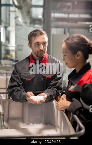 Deux jeunes gestionnaires du contrôle de la qualité discutent des caractéristiques des matières premières Banque D'Images