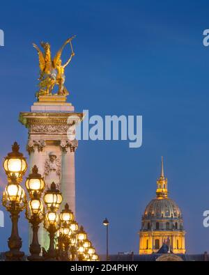 Rangée de lampadaires sur le Pont Alexandre III avec dôme de l'Hôtel des Invalides au-delà, Paris, France Banque D'Images